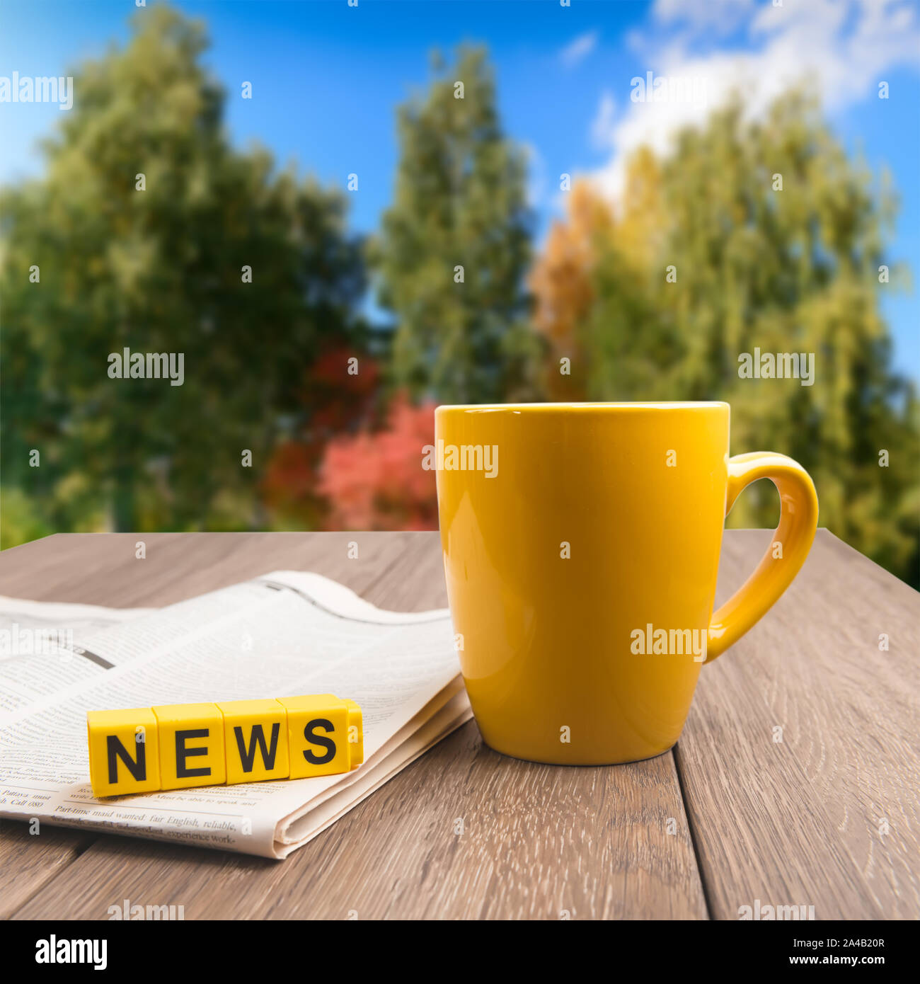 Morning News Concept - taza de café, periódico sobre la mesa de madera sobre otoño otoño colorido antecedentes Foto de stock