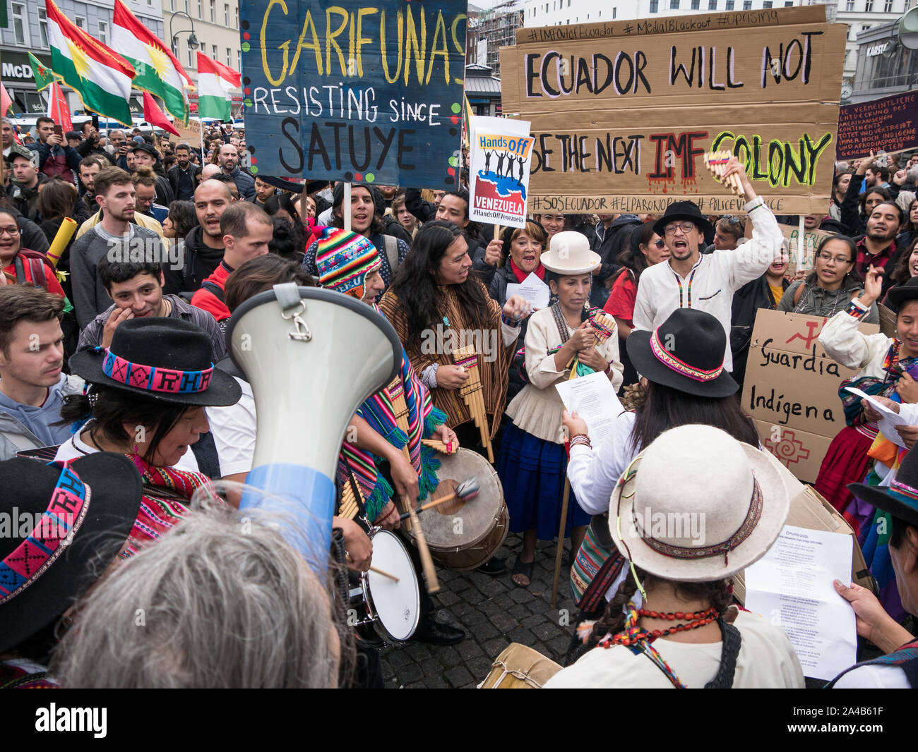 Demostración y protestar contra la política del Presidente Moreno en Ecuador, multitud de gente con ropa tradicional mostrando banners mientras reproduce música. Foto de stock