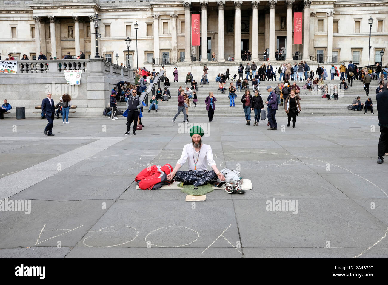 Un hombre meditando en Trafalgar Square, Londres Foto de stock