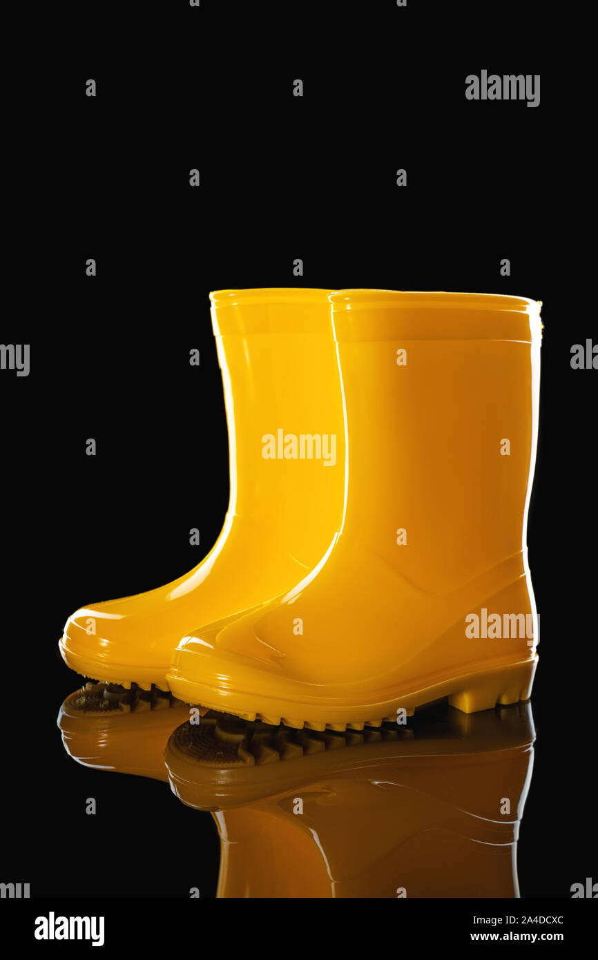 Caucho amarillo botas de para sobre fondo negro Fotografía de - Alamy