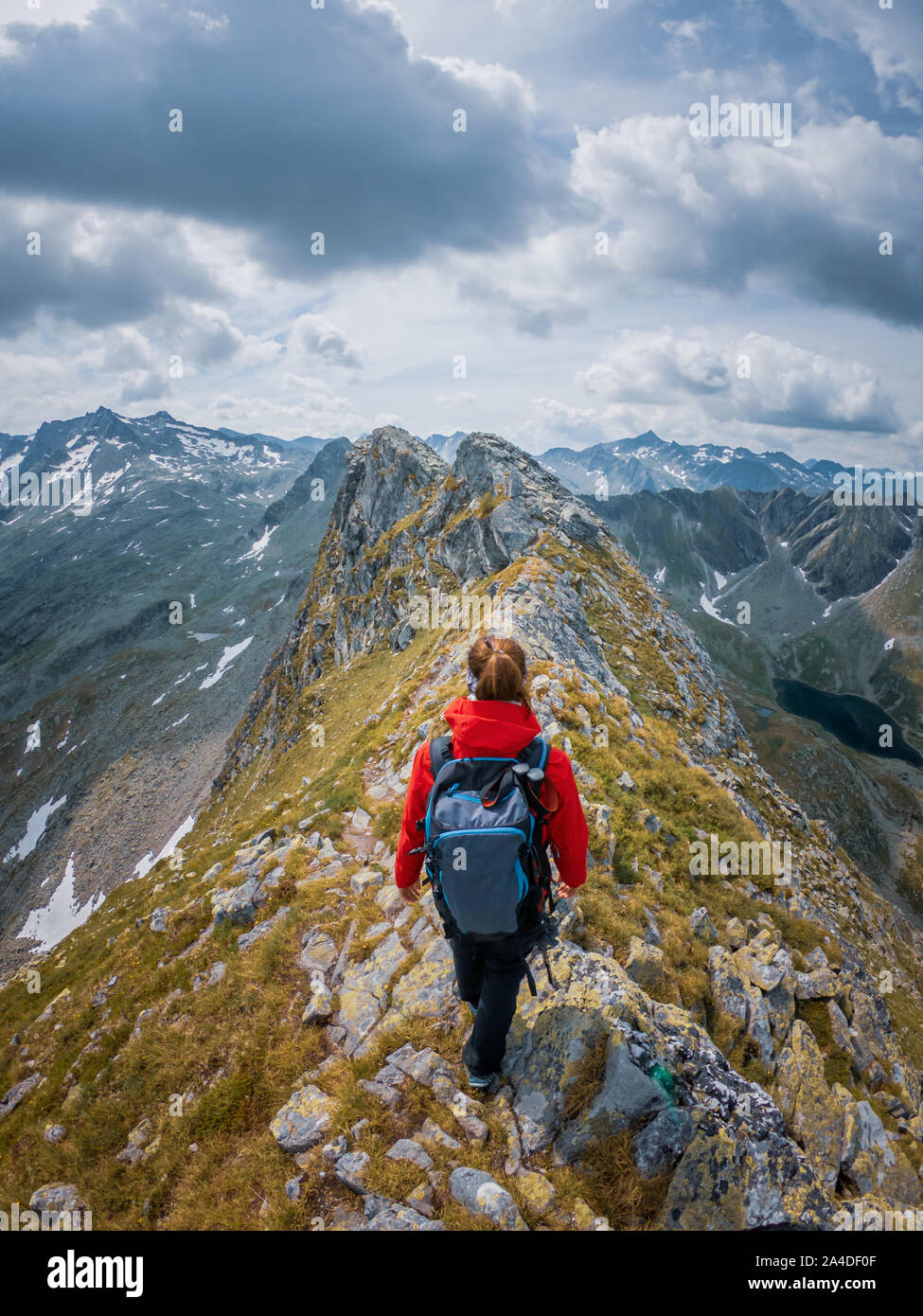 Mujer de senderismo a lo largo de la cresta de una montaña, Alpes Austríacos, Bad Gastein, Salzburgo, Austria Foto de stock