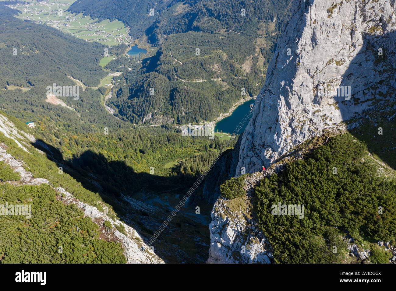 El hombre ve una mujer escalando una vía ferrata, Gosau, Gmunden, Upper Austria, Austria Foto de stock