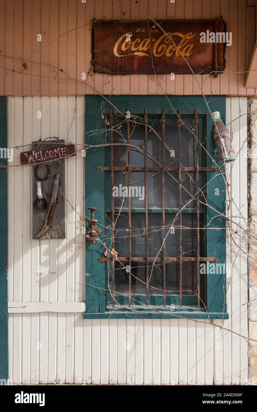 El letrero dice bienvenido, pero las vides contar otra historia en una antigua estación de gas cerca de Pipe Creek, en el condado de bandera, Texas Foto de stock