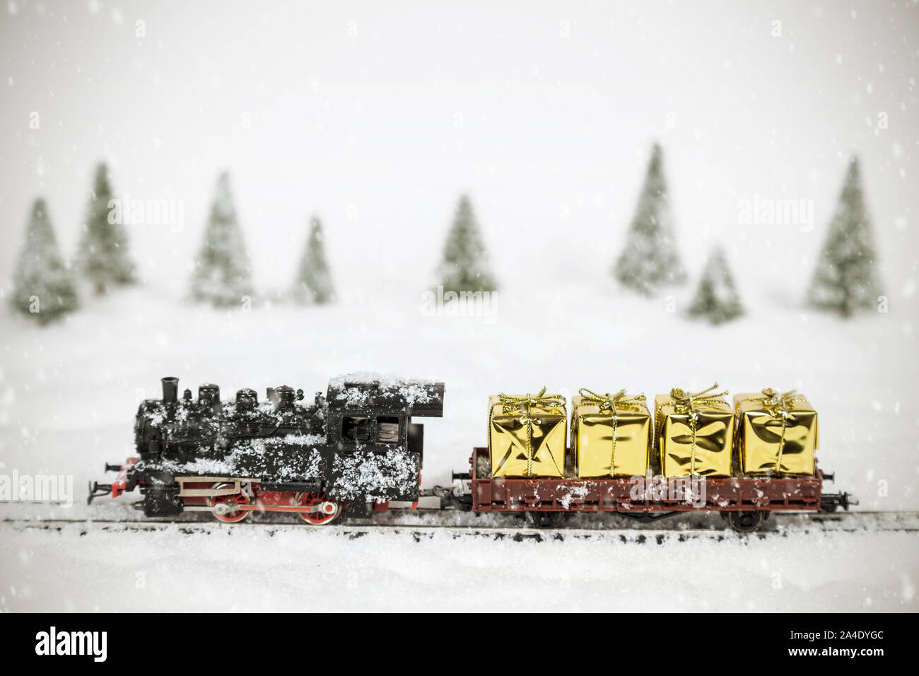 Tren de navidad con cajas de regalo de oro en paisaje de invierno Foto de stock