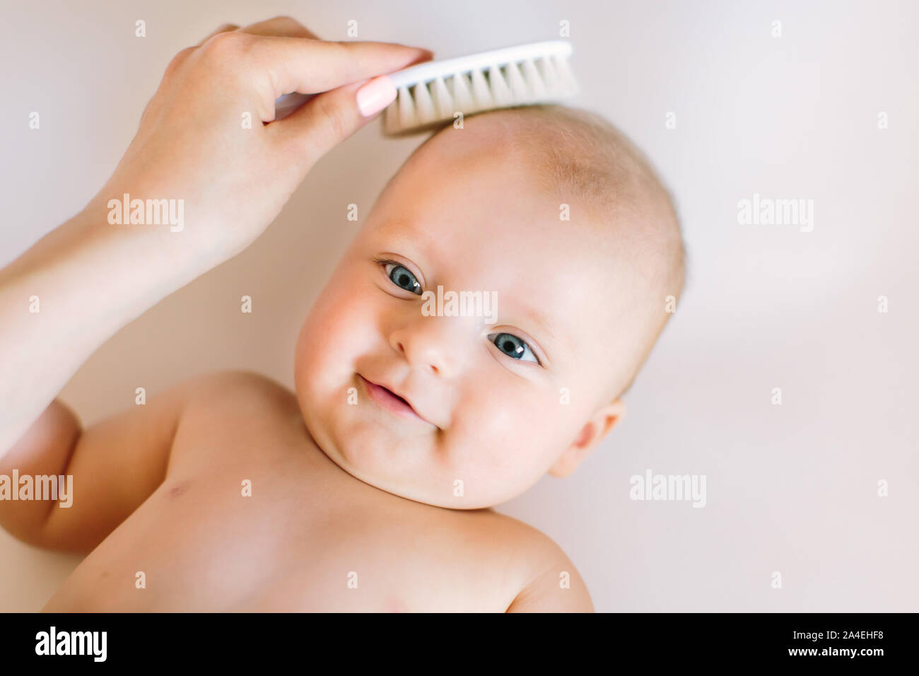 Madre cepillando el cabello de su bebé recién nacido usando un cepillo de  pelo suave para estimular los folículos pilosos del bebé y aumentar el  flujo sanguíneo del cuero cabelludo para un