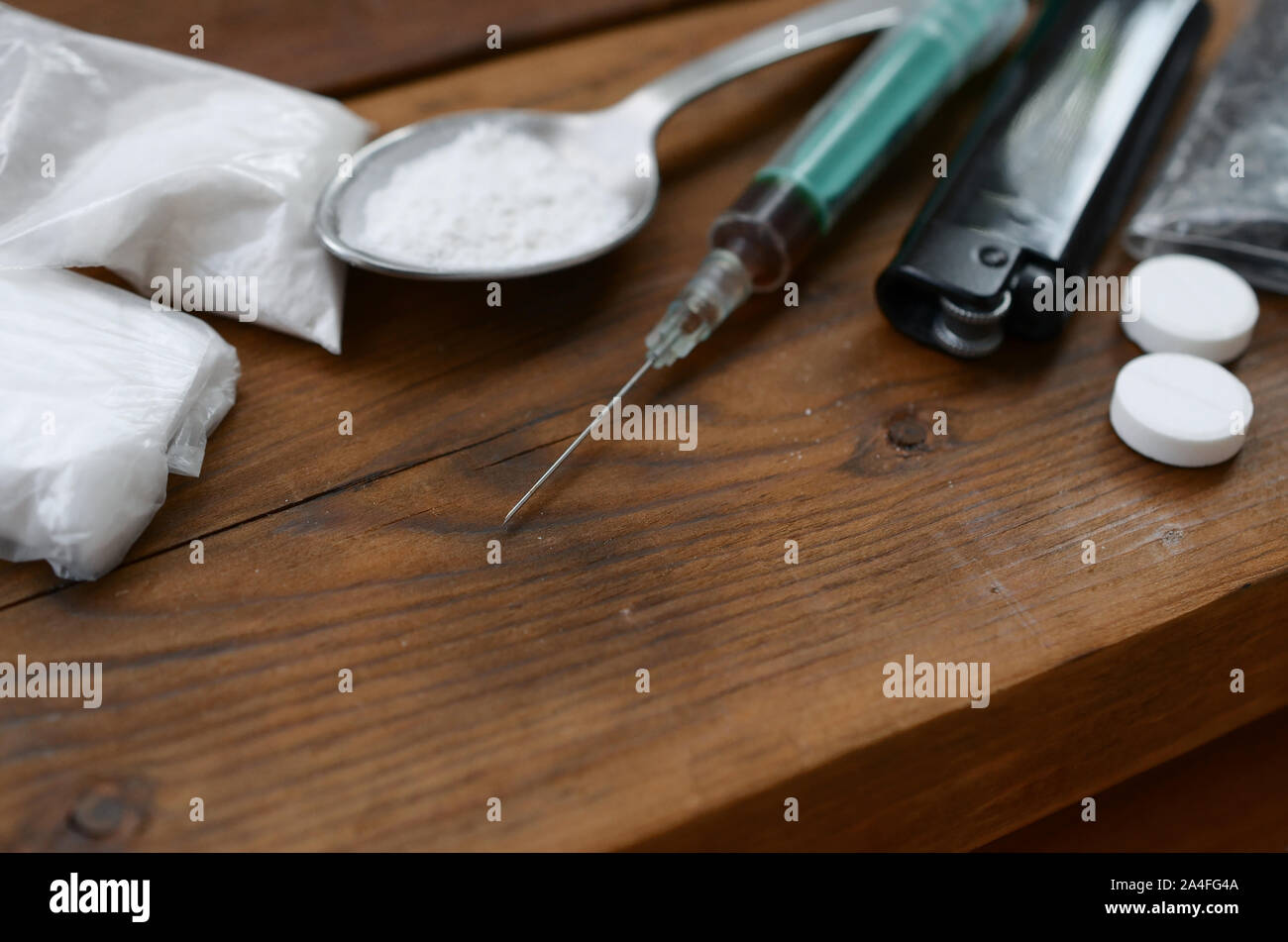Una gran cantidad de sustancias estupefacientes y dispositivos para la preparación de medicamentos acostarse sobre una mesa de madera antigua. Cosas de traficante de drogas. Heroína y metanfetamina en raw Foto de stock