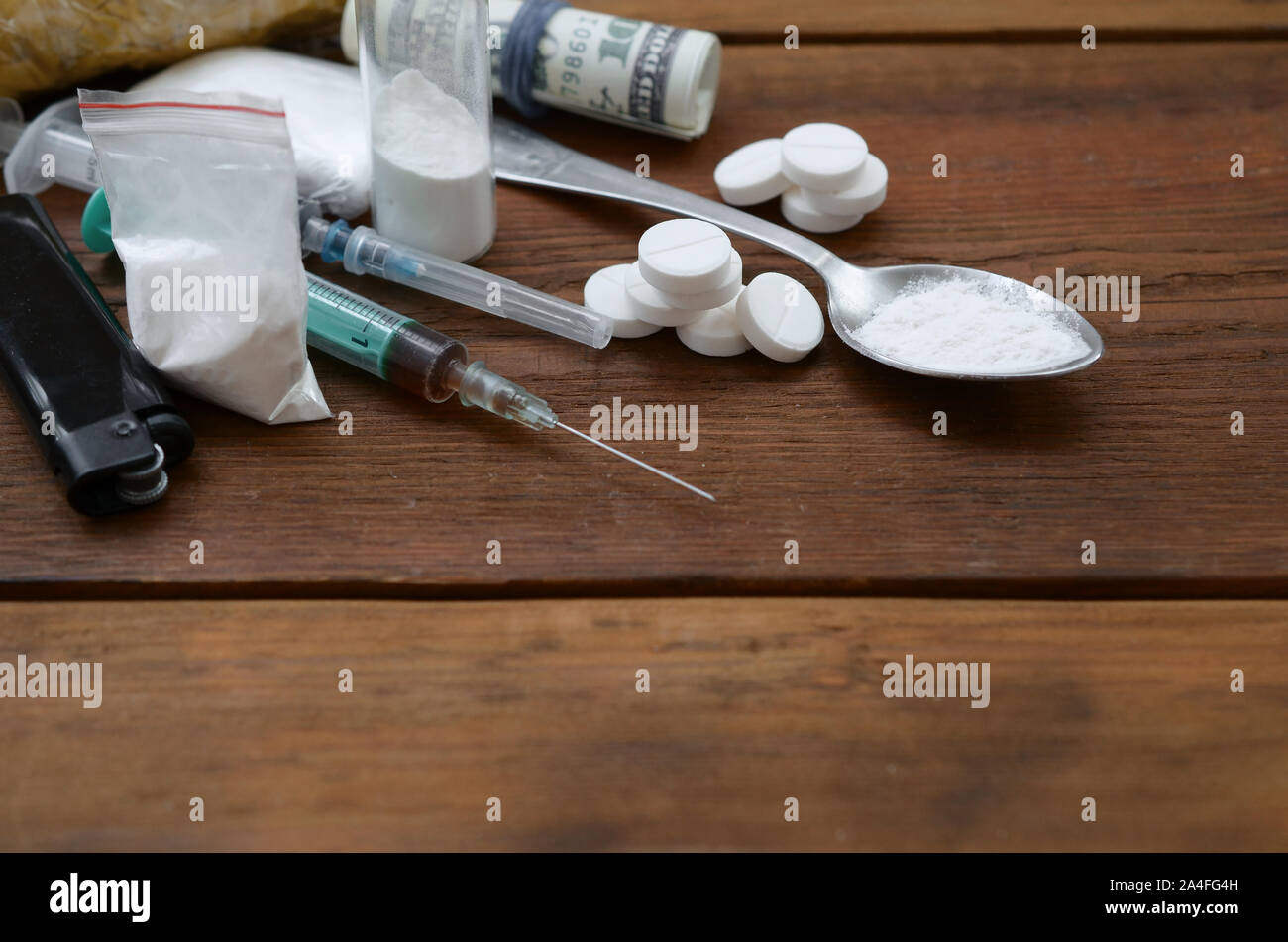 Una gran cantidad de sustancias estupefacientes y dispositivos para la preparación de medicamentos acostarse sobre una mesa de madera antigua. Cosas de traficante de drogas. Heroína y metanfetamina en raw Foto de stock