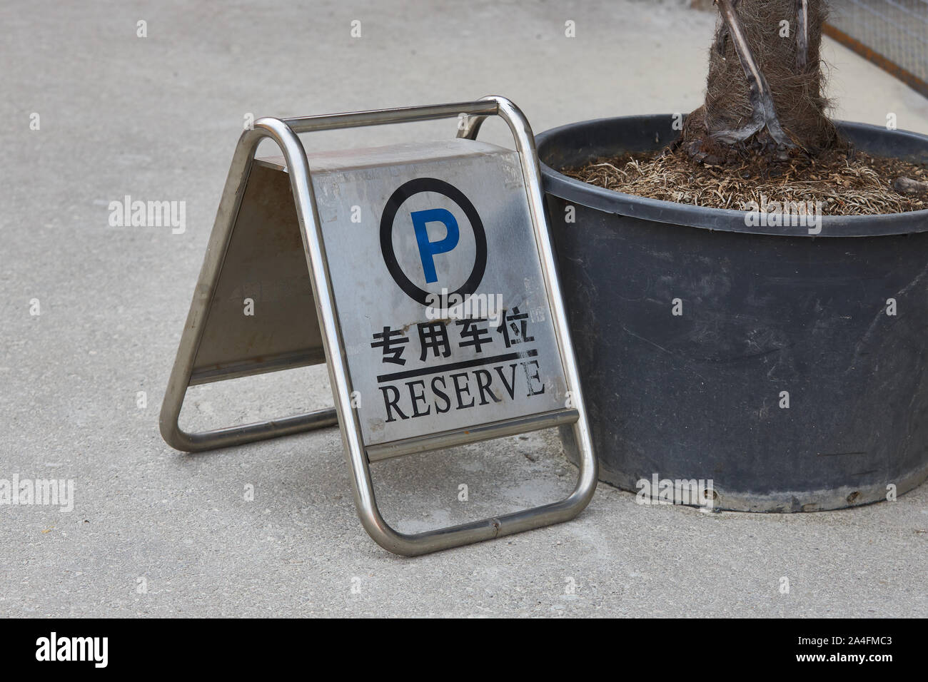 Letrero metálico para reservar una plaza de aparcamiento con una inscripción en diferentes idiomas. Foto de stock