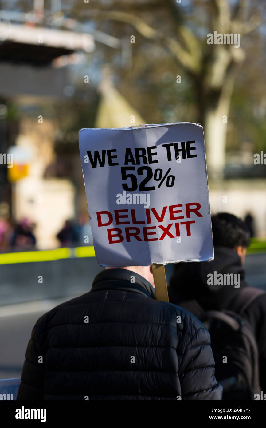 Londres, Reino Unido. Un hombre sostiene un cartel pro-Brexit camina pasado las Casas del Parlamento de Westminster. Foto de stock