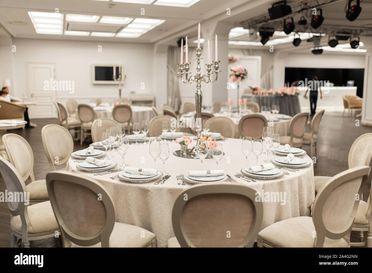 La mesa redonda blanca en el restaurante está decorado con flores frescas.  Elegante decoración de eventos Fotografía de stock - Alamy