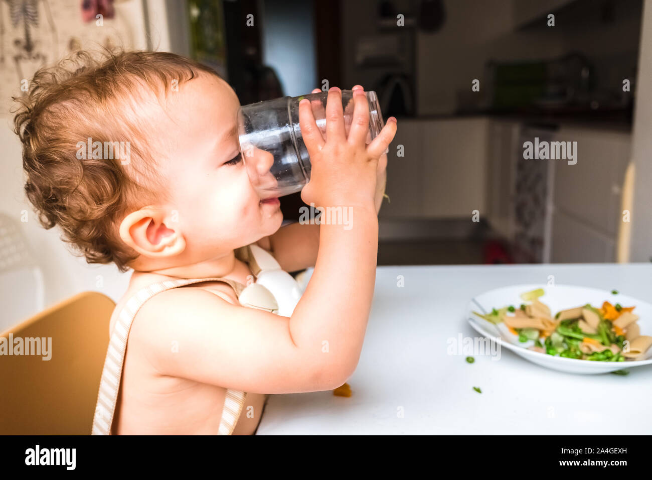 Vaso De Agua Para Beberse Un Bebé. Nutrición Saludable Para Los Niños.  Retrato De Un Bebé Que Bebe En El Ambiente Doméstico. Imagen de archivo -  Imagen de desayuno, cabritos: 277272161