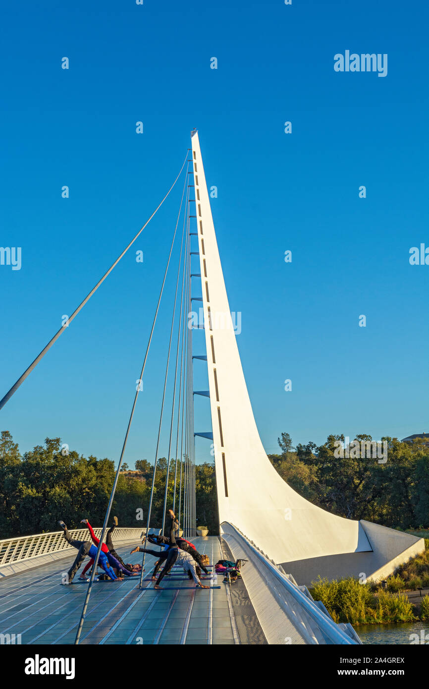 En Redding, California Sundial Bridge en Turtle Bay Exploration Park, abarca Río Sacramento, grupo de yoga Foto de stock