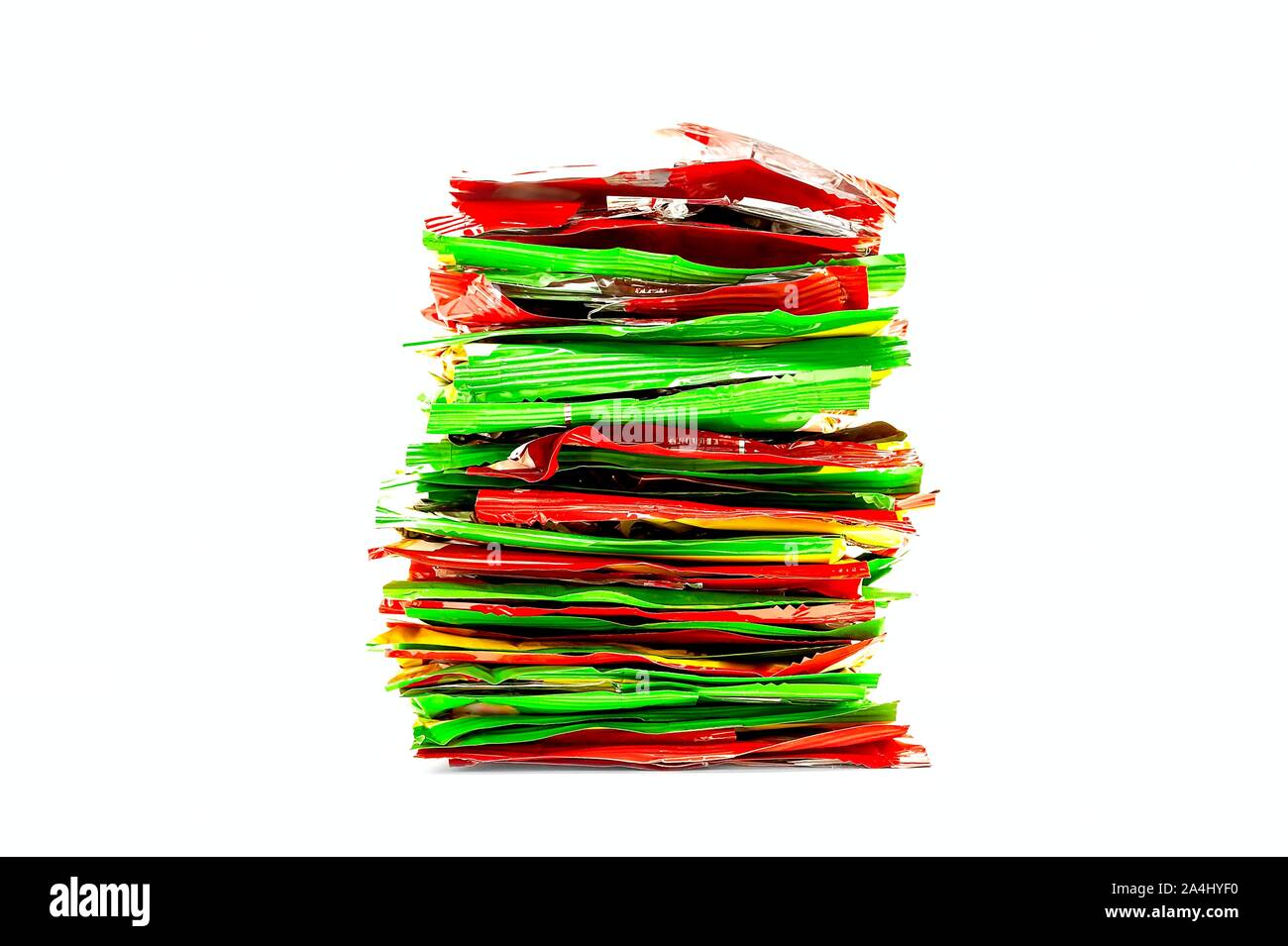 Pila de rojo, amarillo y verde de lámina de plástico de embalaje Snack. Una alimentación insana, concepto de reciclaje. Foto de stock