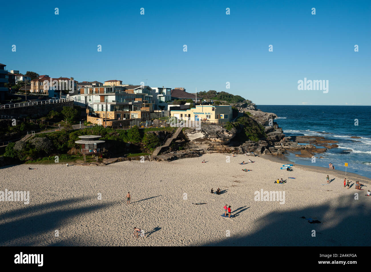24.09.2019, Sydney, New South Wales, Australia - vista elevada de Tamarama Beach bajo un cielo azul claro con edificios en el fondo. Foto de stock
