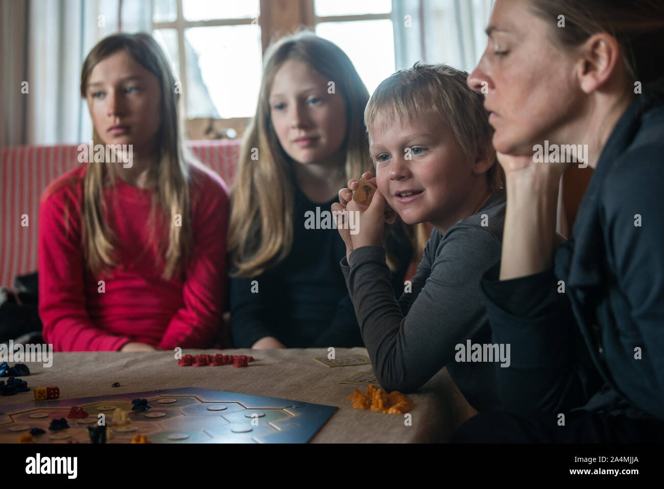 Madre con hijos jugando juegos de tablero Foto de stock