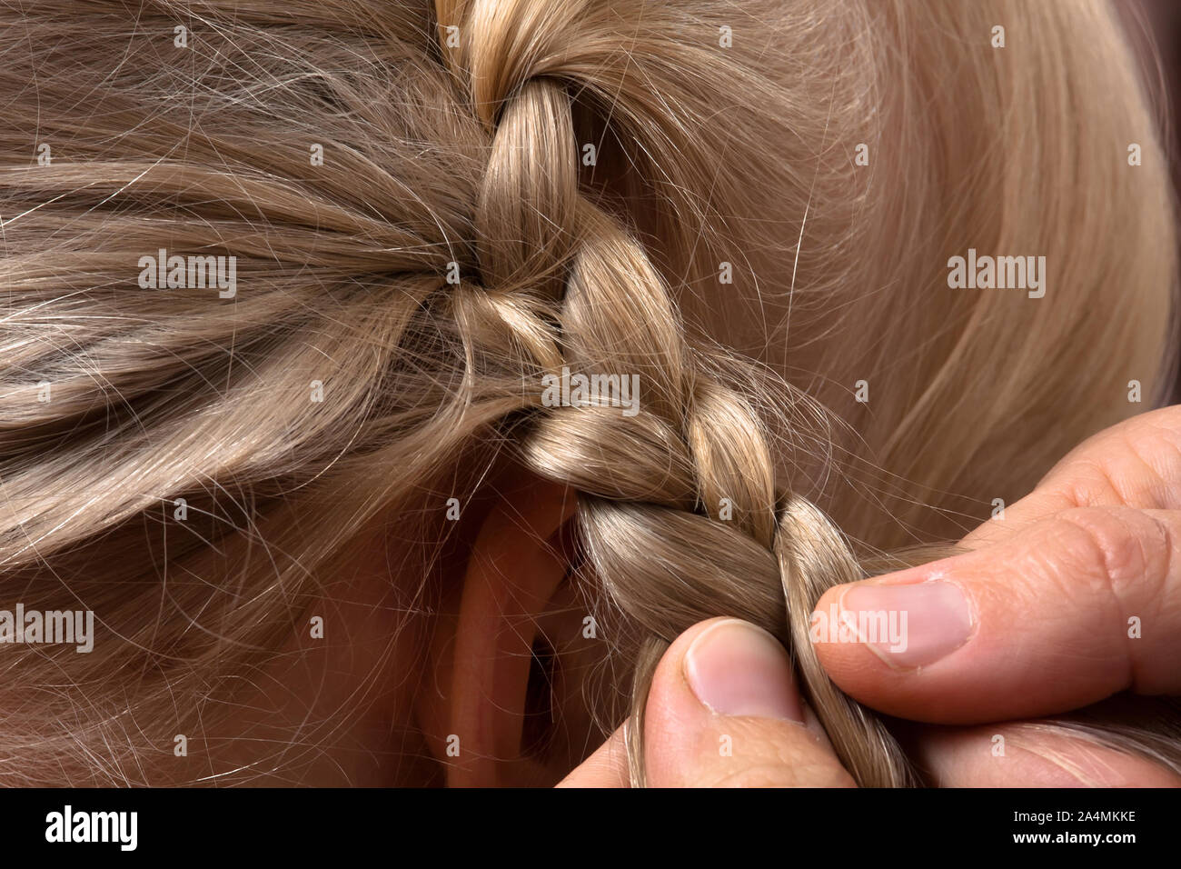 Manos de peluquería trenzas entrelazadas su cliente en peluquería, closeup Foto de stock