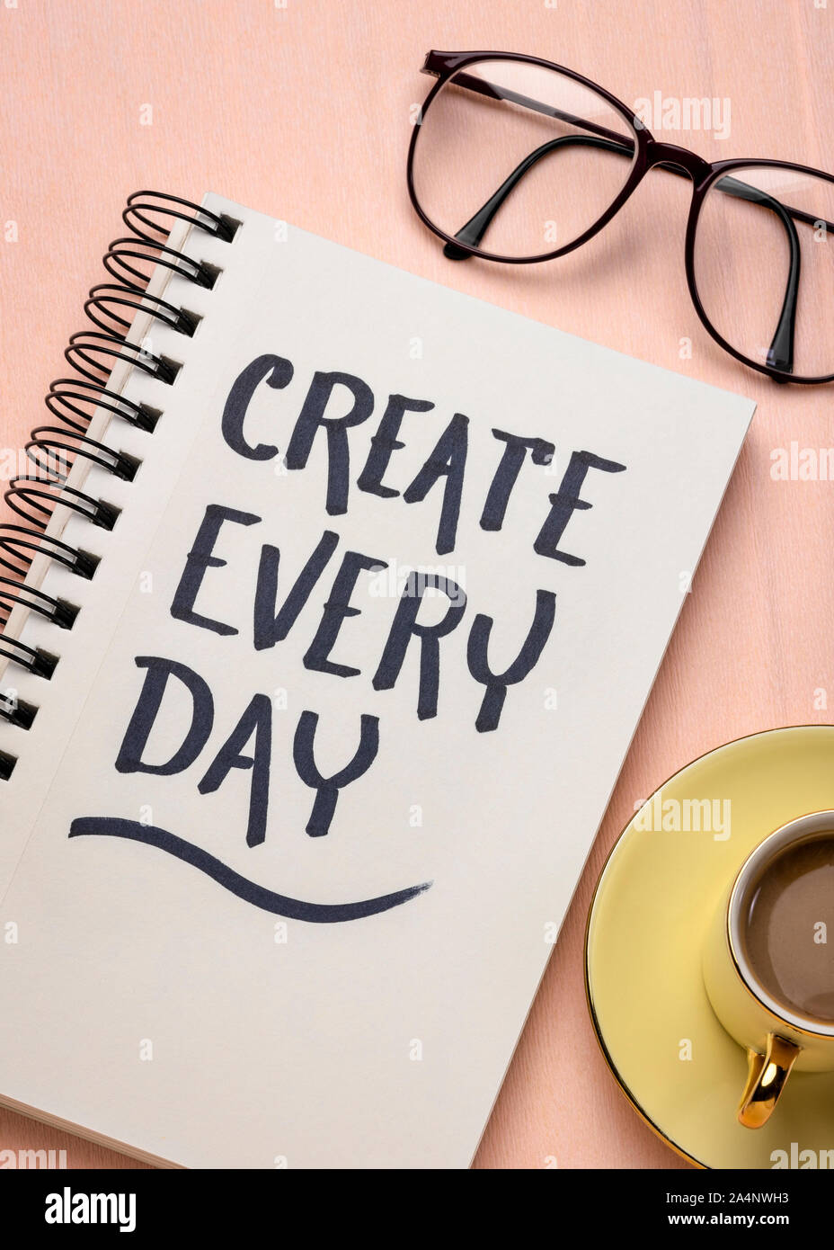 Crear cada día - Recordatorio de inspiración o consejos, la escritura a mano en un cuaderno de bocetos con una taza de café Foto de stock