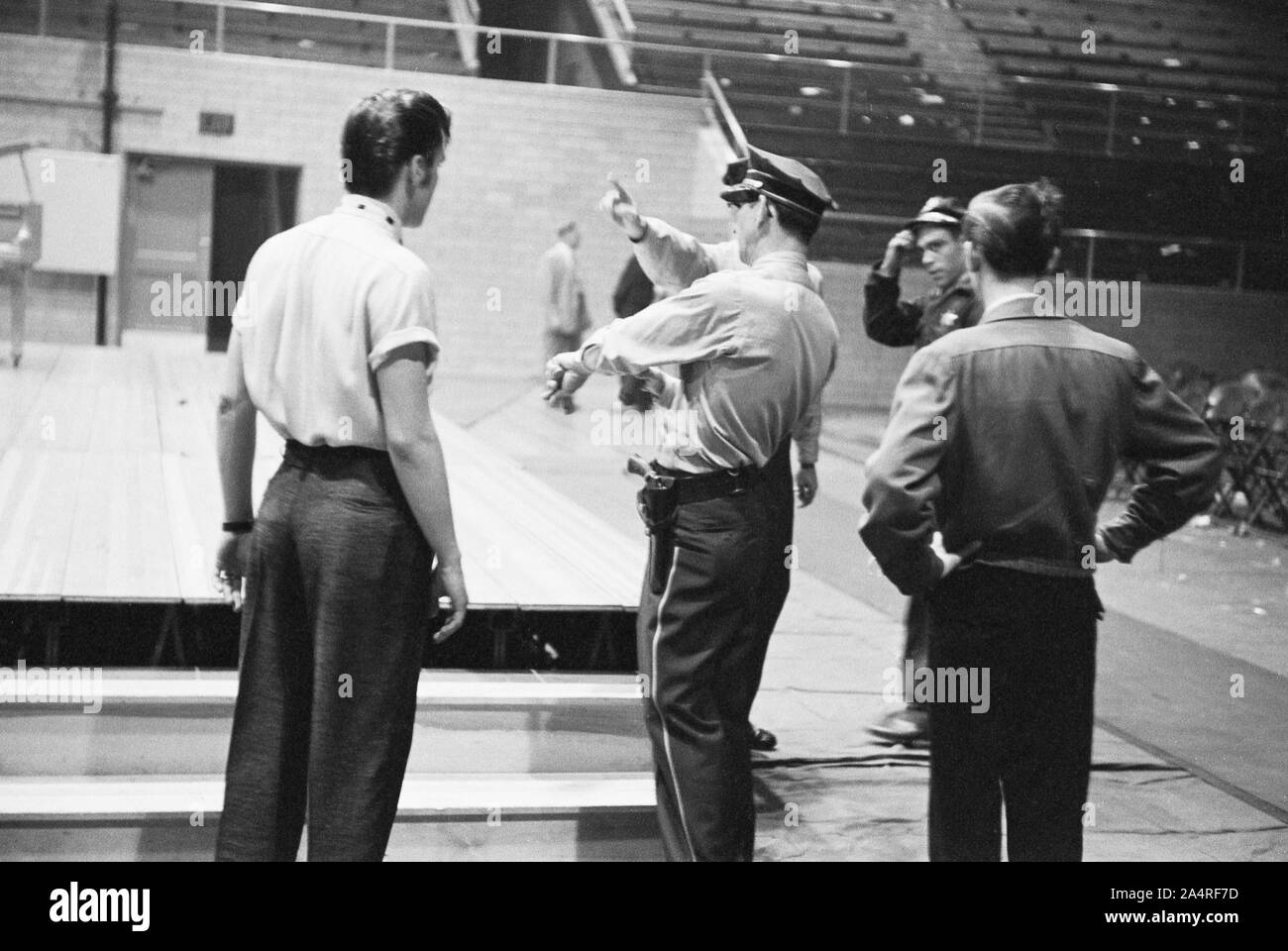 Elvis Presley habla con oficiales de la policía en la Universidad de Dayton Fieldhouse, 27 de mayo de 1956. Foto de stock