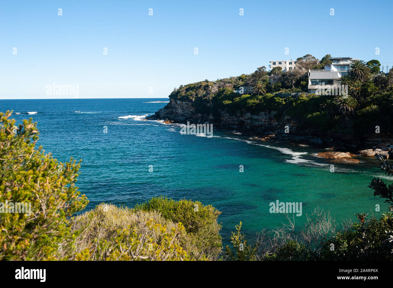 24.09.2019, Sydney, New South Wales, Australia - Vista de una pequeña bahía en el bondi de Coogee camina bajo un cielo azul claro. Foto de stock