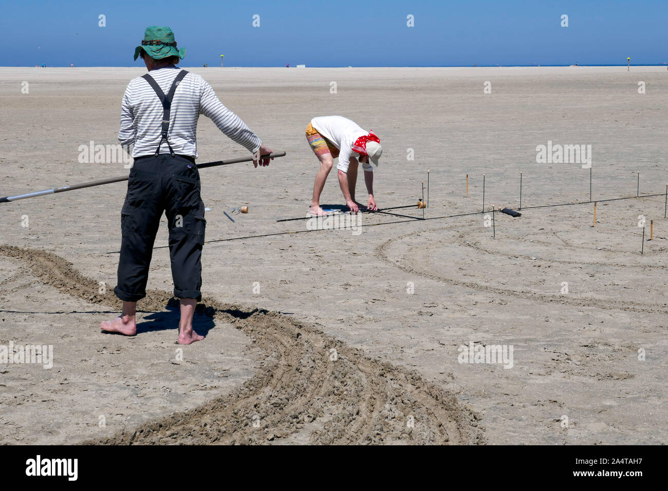 Crear dibujos en la arena en la playa en Holanda Foto de stock