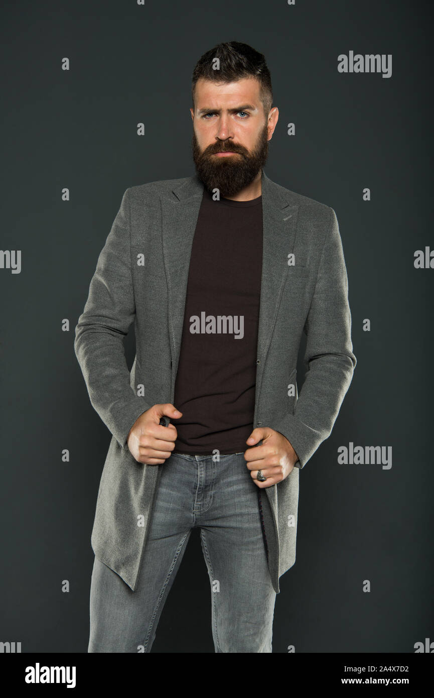 Hipster brutal del hombre. Hipster vistiendo ropa casual. Hipster con barba  y cabello peinado elegante. Hombre Barbado moderno estilo HIPSTER.  Chaqueta. Traje de diario. Caída de la moda. Mantener la mirada masculina