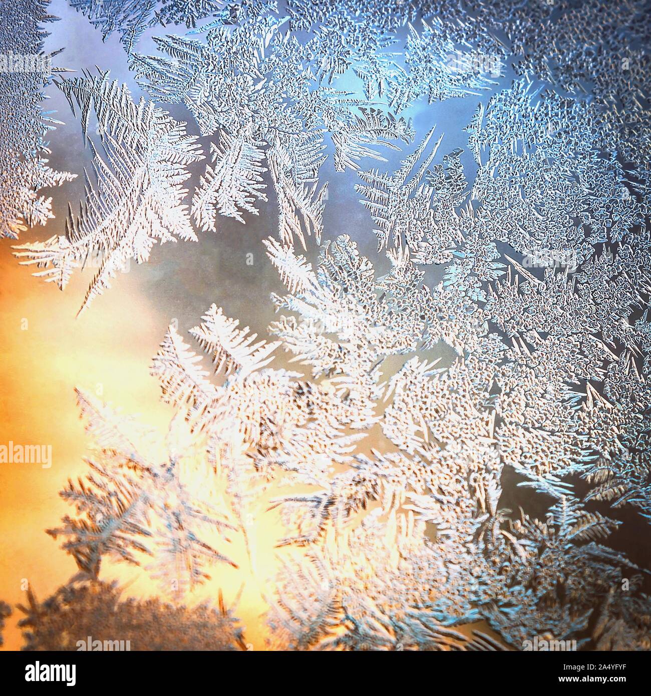 El vidrio de la ventana helada con hielo natural y patrones de fondo de colores borrosos. La temporada de vacaciones de invierno, el concepto de mundo de fantasía. Foto de stock
