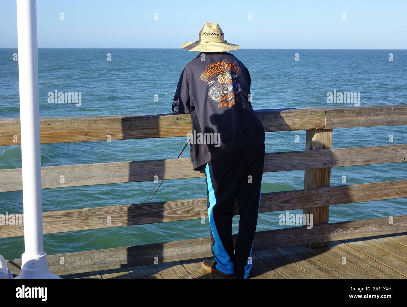 Pescador espera una mordedura en el Daytona Beach Pier Foto de stock