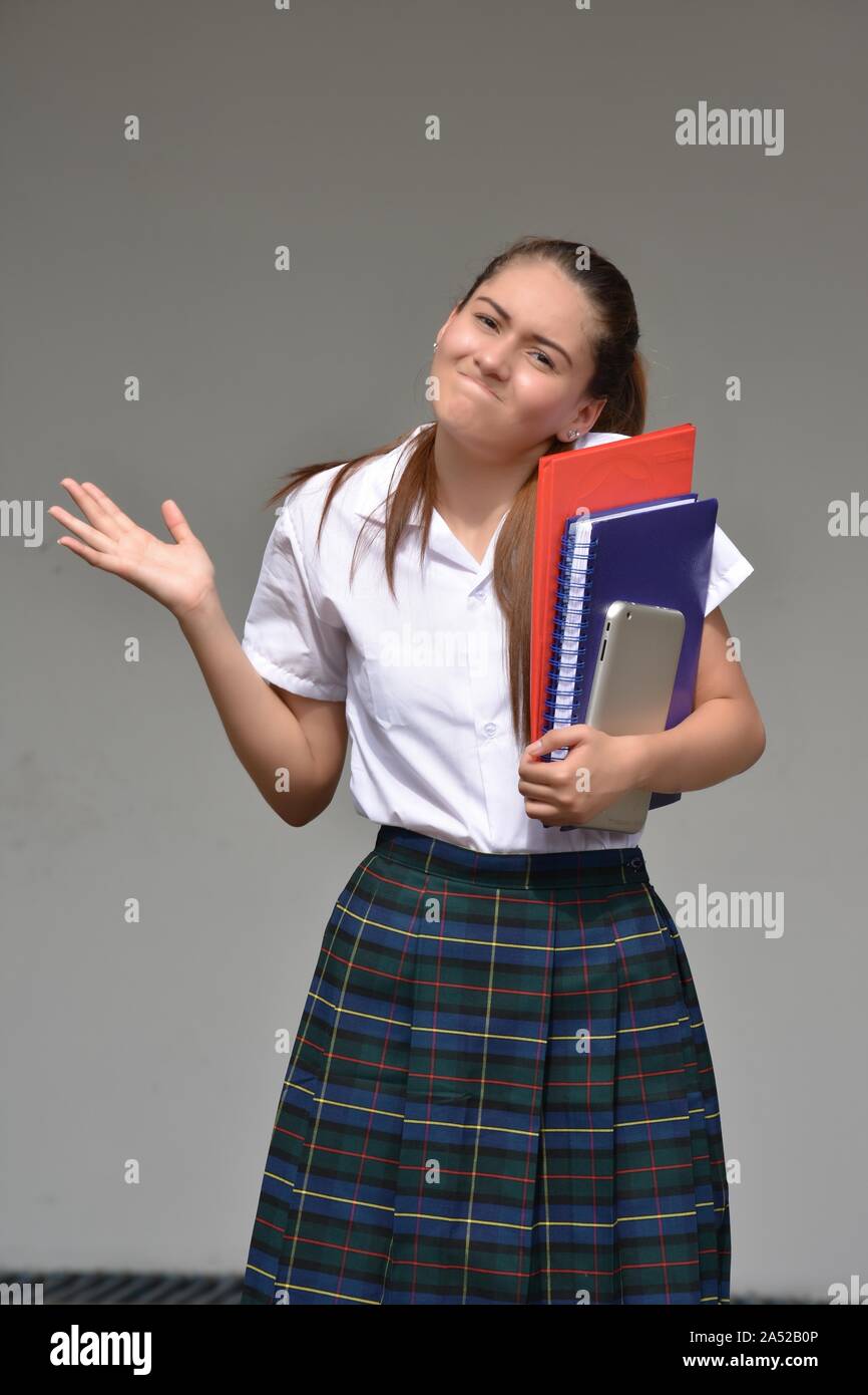 Estudiante de sexo femenino y la Indecisión vistiendo uniforme escolar con  libros Fotografía de stock - Alamy