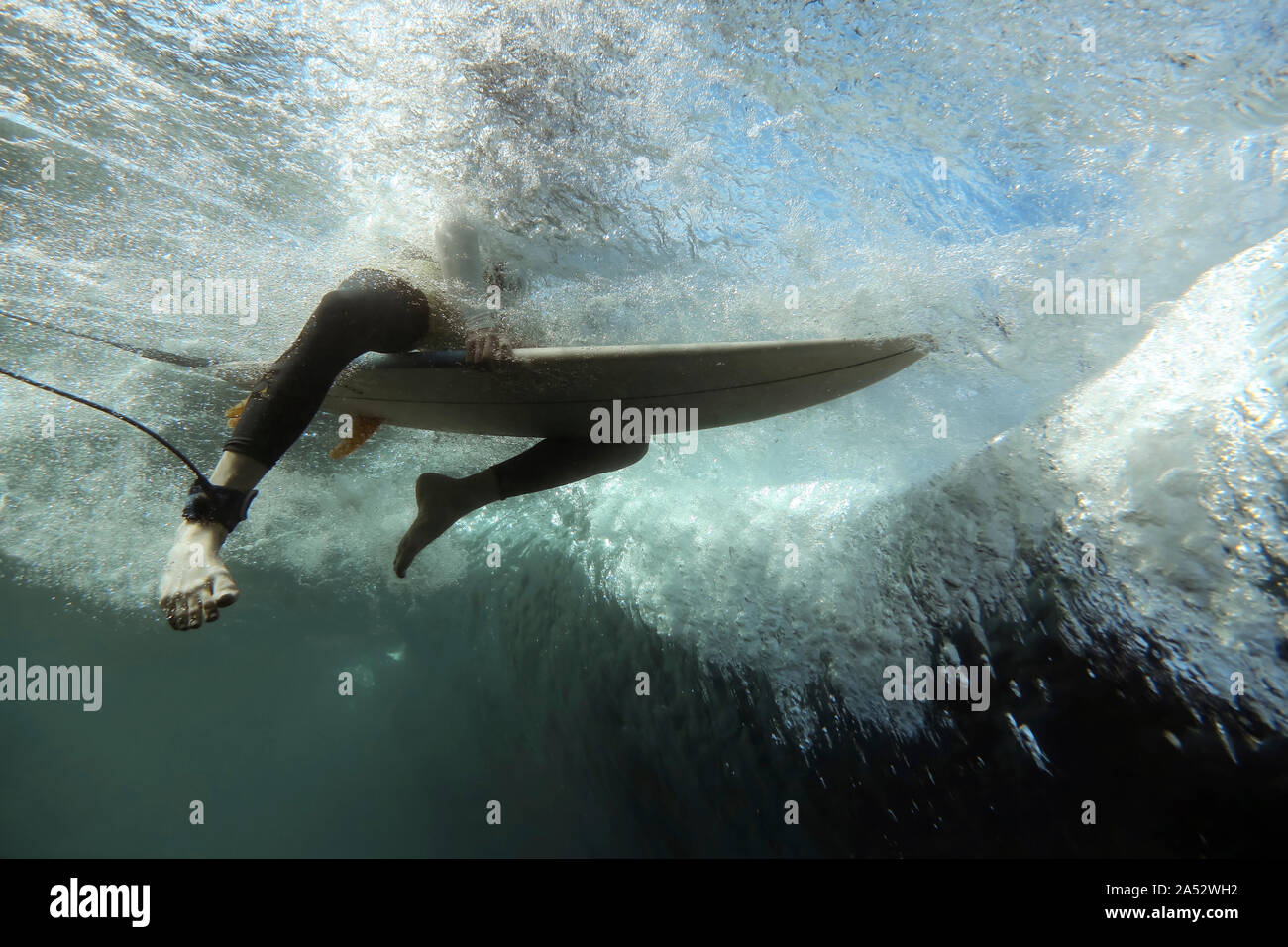 Bajo el agua vista de onda, surfer sentados sobre tablas de surf, filmación subacuática, Sumbawa, Indonesia Foto de stock