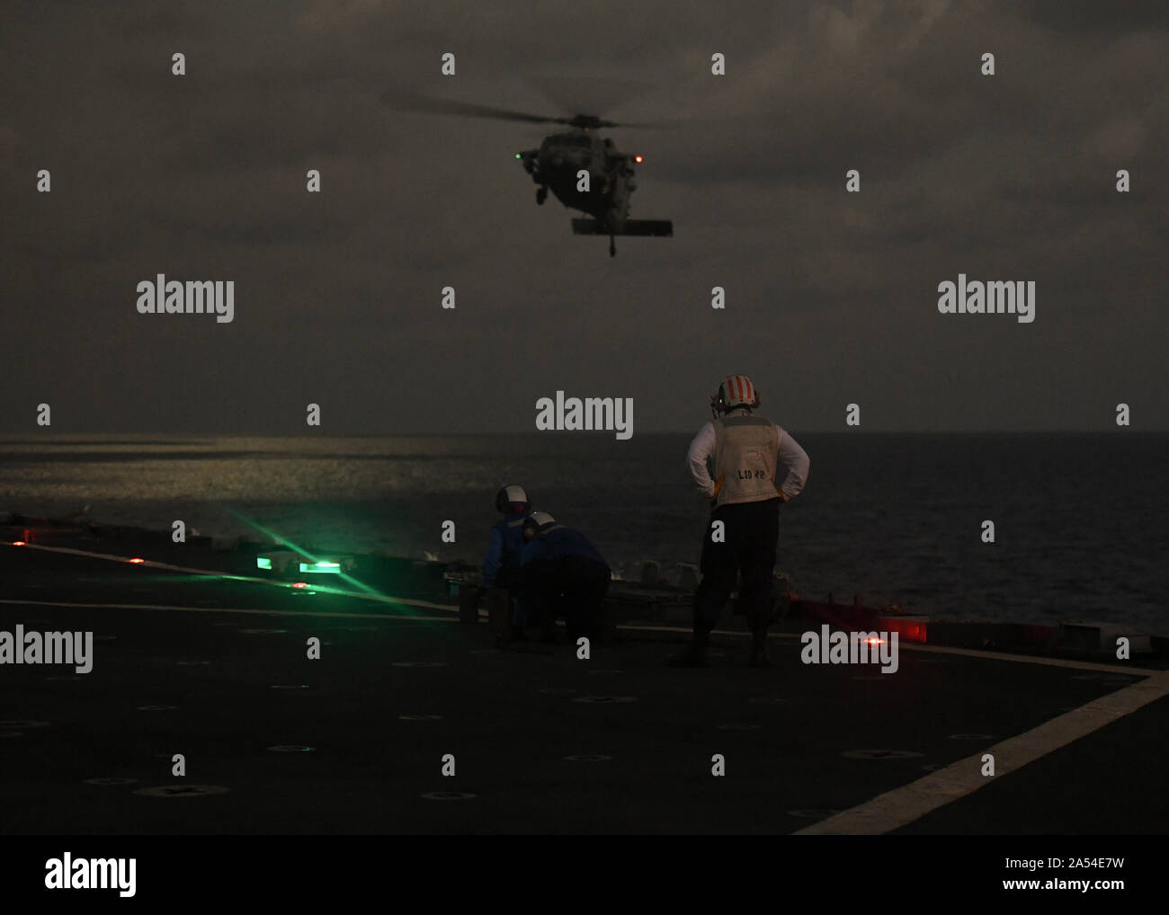 La Bahía de Manila (Oct. 11, 2019) U.S. Navy marineros observe un MH-60S Sea Hawk de la cubierta de vuelo de la clase Whidbey Island dock desembarque barco USS Germantown (LSD 42) durante el ejercicio KAMANDAG 3. El Germantown está participando en 3 KAMANDAG, filipino-led, ejercicio bilateral con los EE.UU., diseñada para aumentar el antiterrorismo, la asistencia humanitaria y de socorro en casos de desastre militar de capacidades a través de intercambios que potencien la colaboración y la capacidad de responder rápidamente a las crisis en toda la región del Indo-Pacífico. KAMANDAG es un acrónimo de la frase "Filipinos Kaagapay ng mga Ng Mandirigma Foto de stock