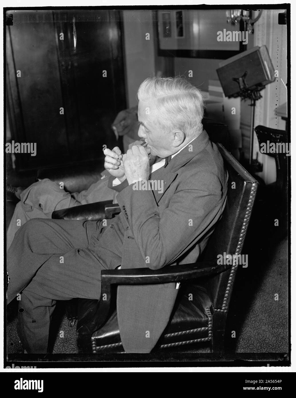 El veterano Senador de Nebraska. Washington, D.C., el 15 de mayo. El senador George W. Norris, Independent-Republican desde Nebraska, luces un stogie mientras asistía a la audiencia judicial del Senado el otro día, el 5/15/1937 Foto de stock