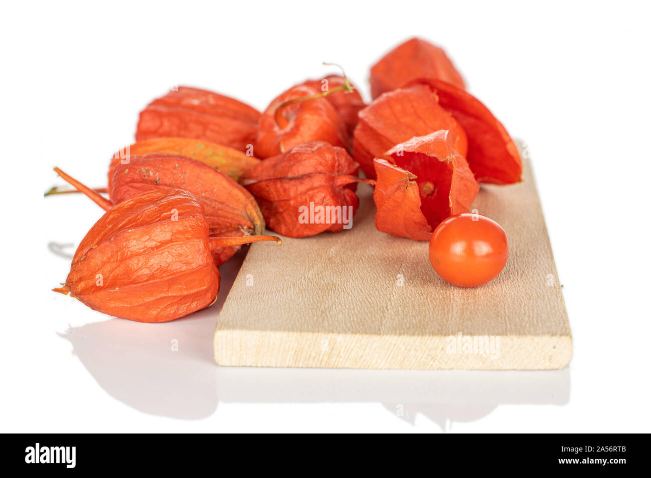 Montón de naranja fresco entero physalis en tabla de cortar de madera aislado sobre fondo blanco. Foto de stock