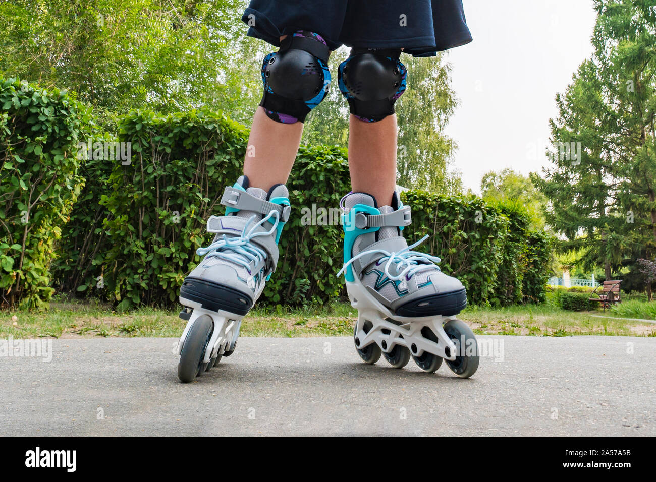 Acercamiento patines blancos o patinar. Patines en las piernas de un niño en parque. Chica piernas en patinas Fotografía de stock - Alamy