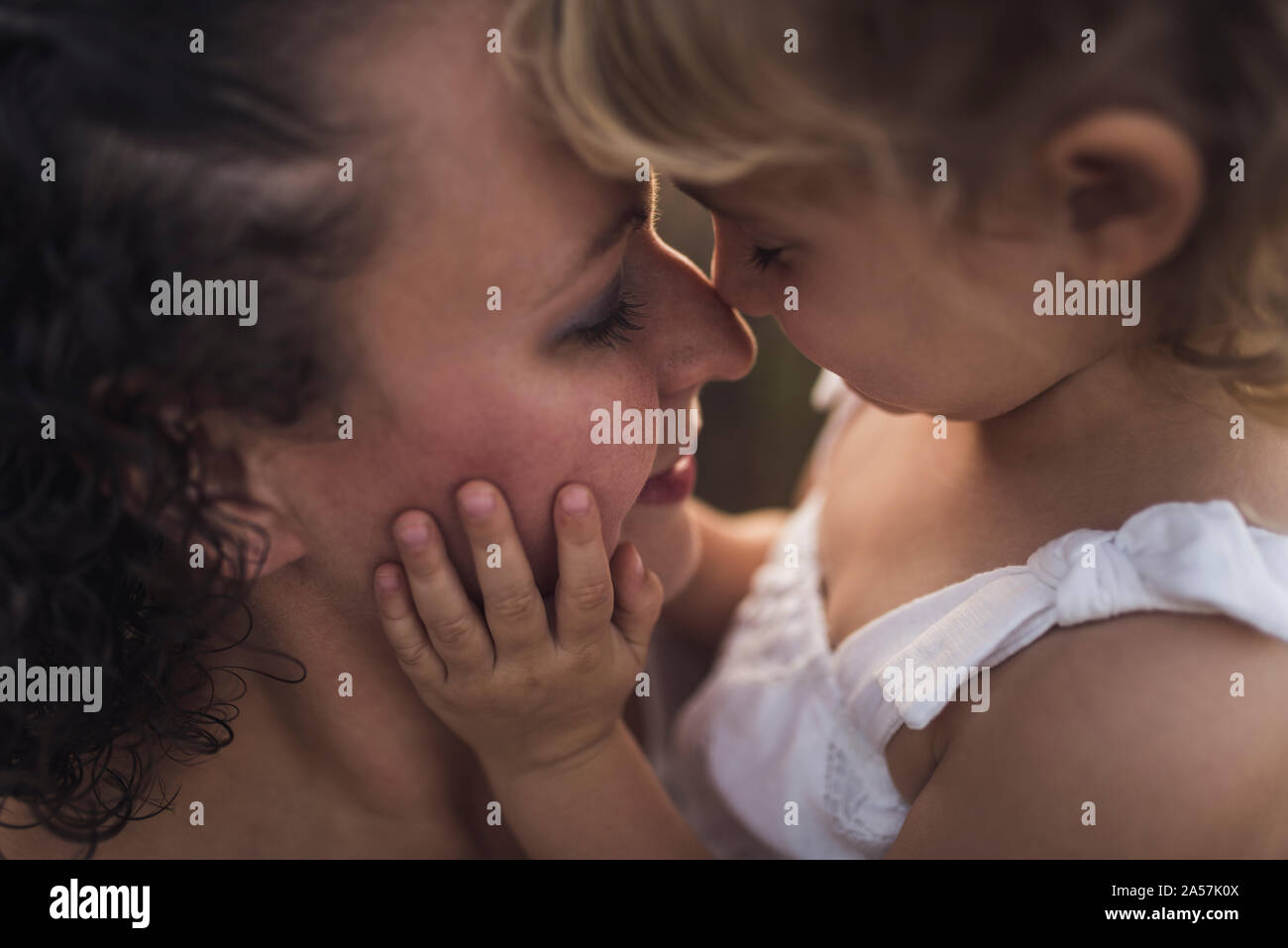 Momento de licitación como niña y mamá tocarse la nariz con los ojos cerrados Foto de stock