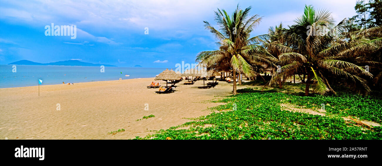 La sombrilla con palmeras en la playa de Cua Dai, Hoi An, de la provincia de Quang Nam, Vietnam Foto de stock