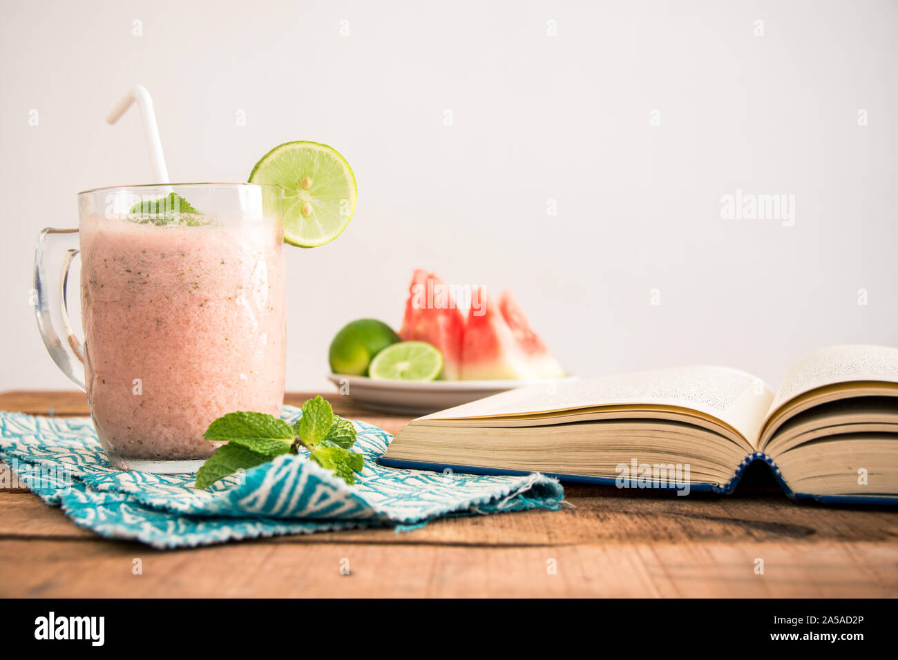 Una plana cuadrada (laicos ración) Foto con mesa de desayuno batido de sandía, libro de teléfono y rodajas de frutas en la placa -alimentos y dietas concepto imagen. Foto de stock