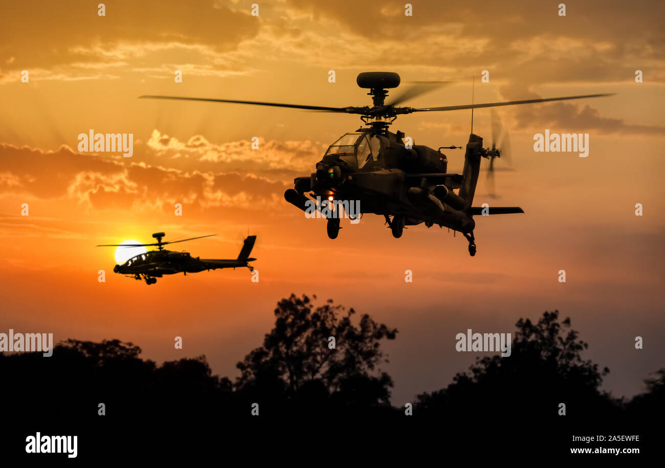 Dos Agusta Westland AH-1 / Arco AH-64 Apache helicópteros artillados siluetas al atardecer Foto de stock