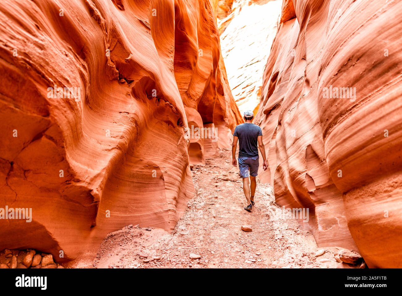 El hombre caminante caminando por onda roja formaciones en forma de ranura Antelope Canyon en Arizona en sendero sendero del Lago Powell Foto de stock