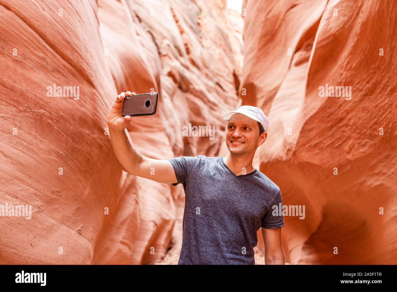 Forma de onda naranja rojo formaciones y hombre tomando selfie fotografía con teléfono en estrecha ranura Antelope Canyon en Arizona en sendero sendero del Lago Powell Foto de stock
