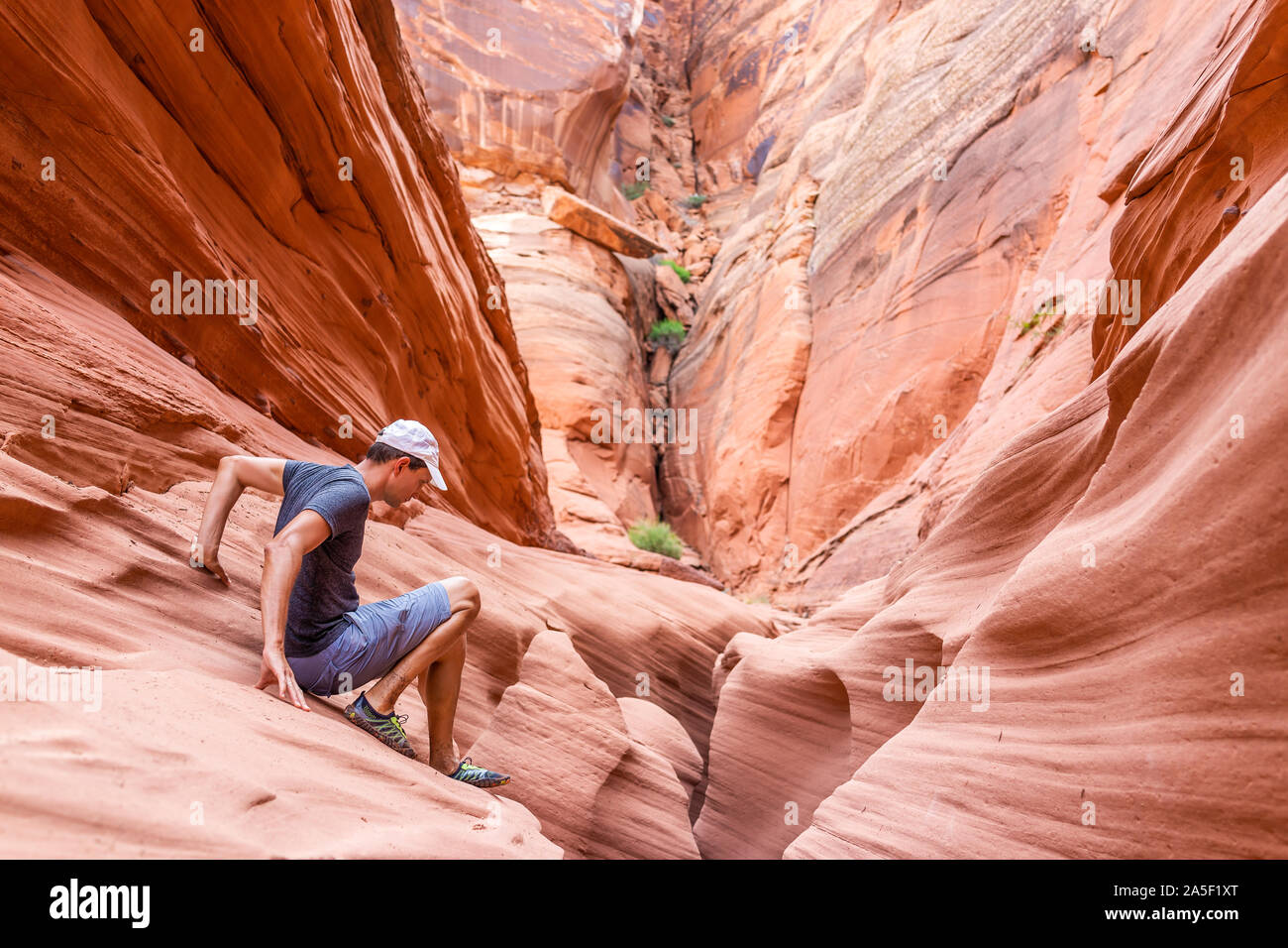 Naranja rojo ola arenisca formaciones abstractas y man subir rocas en estrecha ranura Antelope Canyon en Arizona en el trayecto desde el Lago Powell Foto de stock