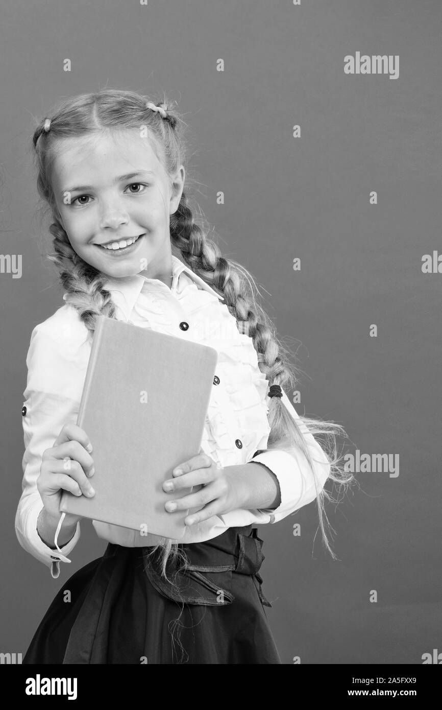 Si el conocimiento que necesita, usted debe leer. Cute little niño sosteniendo un libro sobre fondo rojo, la pequeña niña con conocimiento del libro en las manos. Conocimiento de día o 1 de septiembre. La acumulación de conocimientos, copie el espacio. Foto de stock