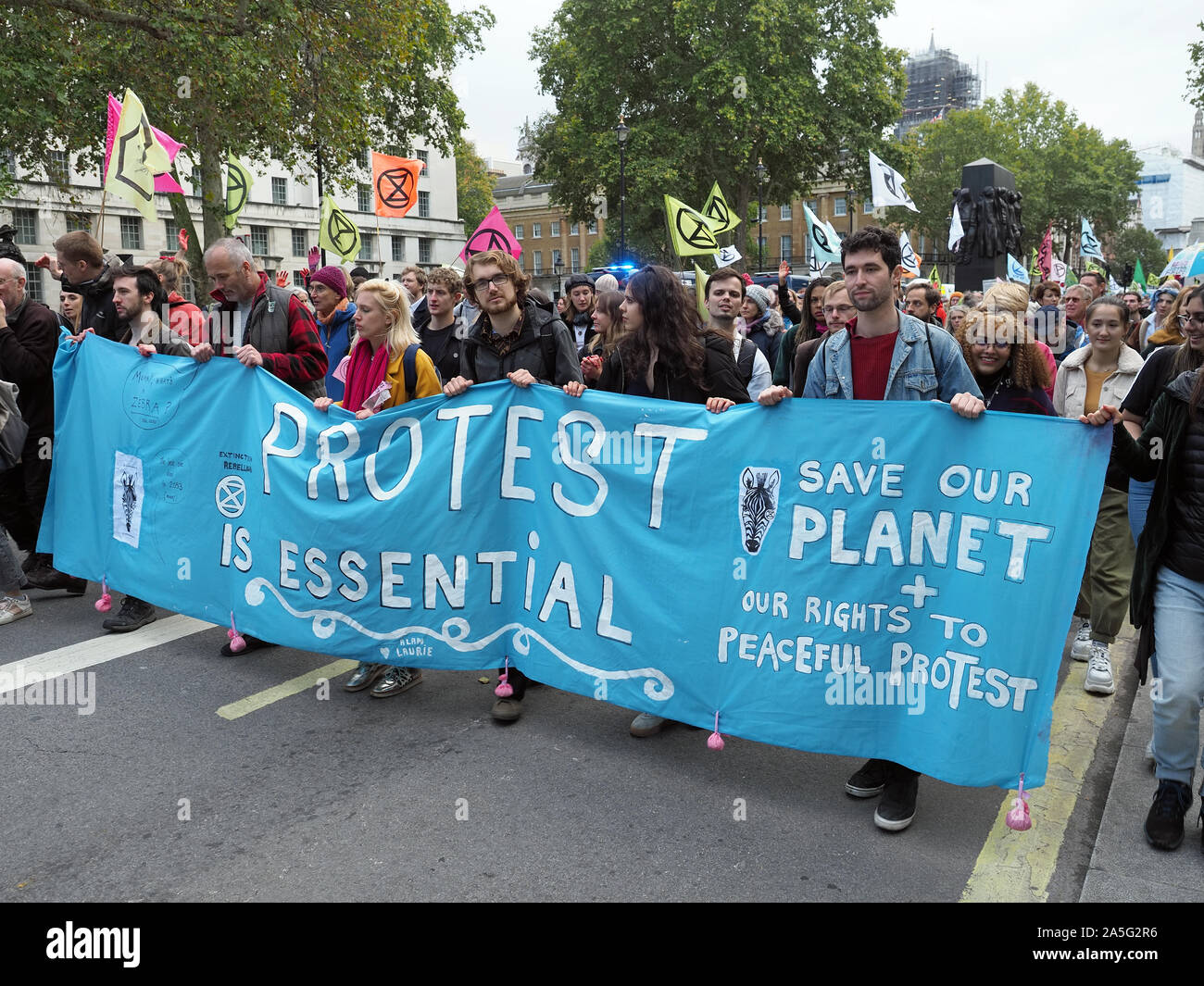 Vista de extinción rebelión manifestantes marchando hacia abajo Whitehall en Londres durante una marcha el viernes 18 de octubre de 2019 Foto de stock
