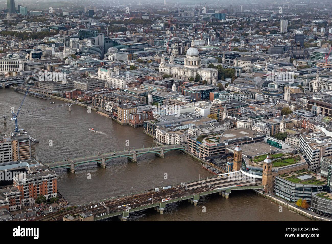 Una vista aérea, mirando al oeste hasta el río Támesis en Londres, mostrando Southwark Bridge, puente de ferrocarril, Millennium Bridge y la Catedral de St. Paul. Foto de stock