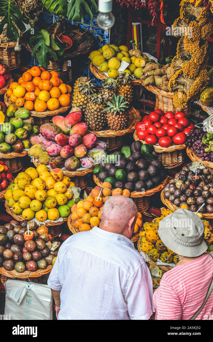 Funchal, Madeira, Portugal - Sep 21, 2019: Los turistas comprando frutas y verduras en el mercado de los Lavradores mercado tradicional en la capital de Madeira. Frutas tropicales coloridos. Las frutas exóticas. Foto de stock