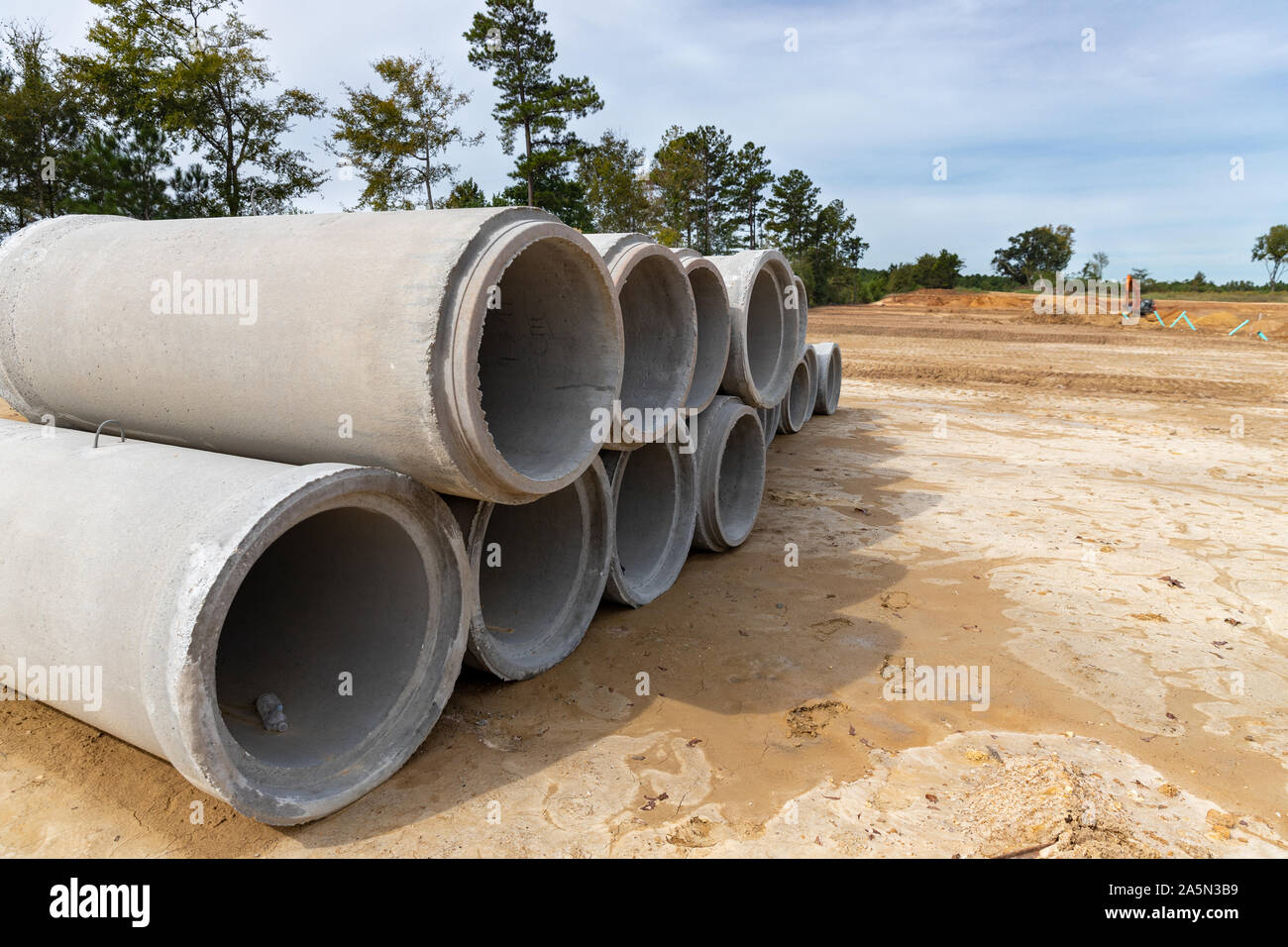 Los tubos de drenaje de prefabricados de hormigón apilados en el sitio de construcción para nuevos inicio desarrollo Foto de stock