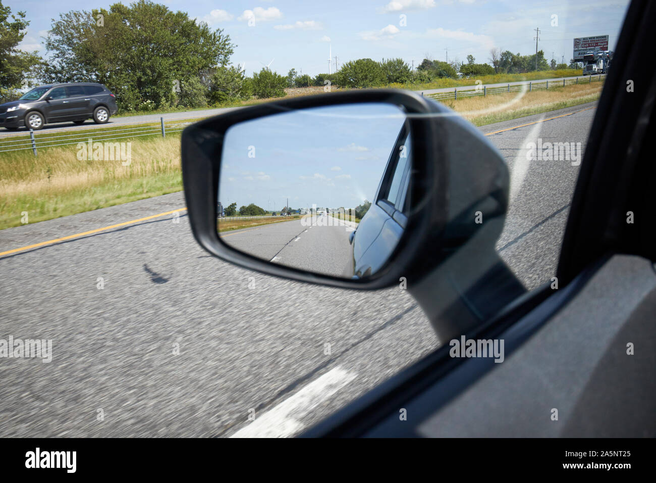 Buscando en coche espejo lateral aleta conduciendo a lo largo de la interestatal, Indiana (Estados Unidos) Foto de stock
