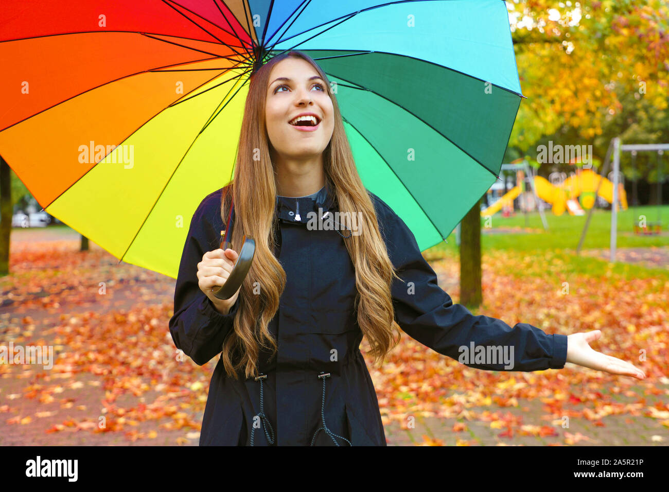 Mujer feliz con sombrilla bajo la lluvia durante el otoño de paseo por el  bosque. Chica disfrutando lluvioso día de otoño, mirando hacia el cielo  sonriendo alegre Fotografía de stock - Alamy