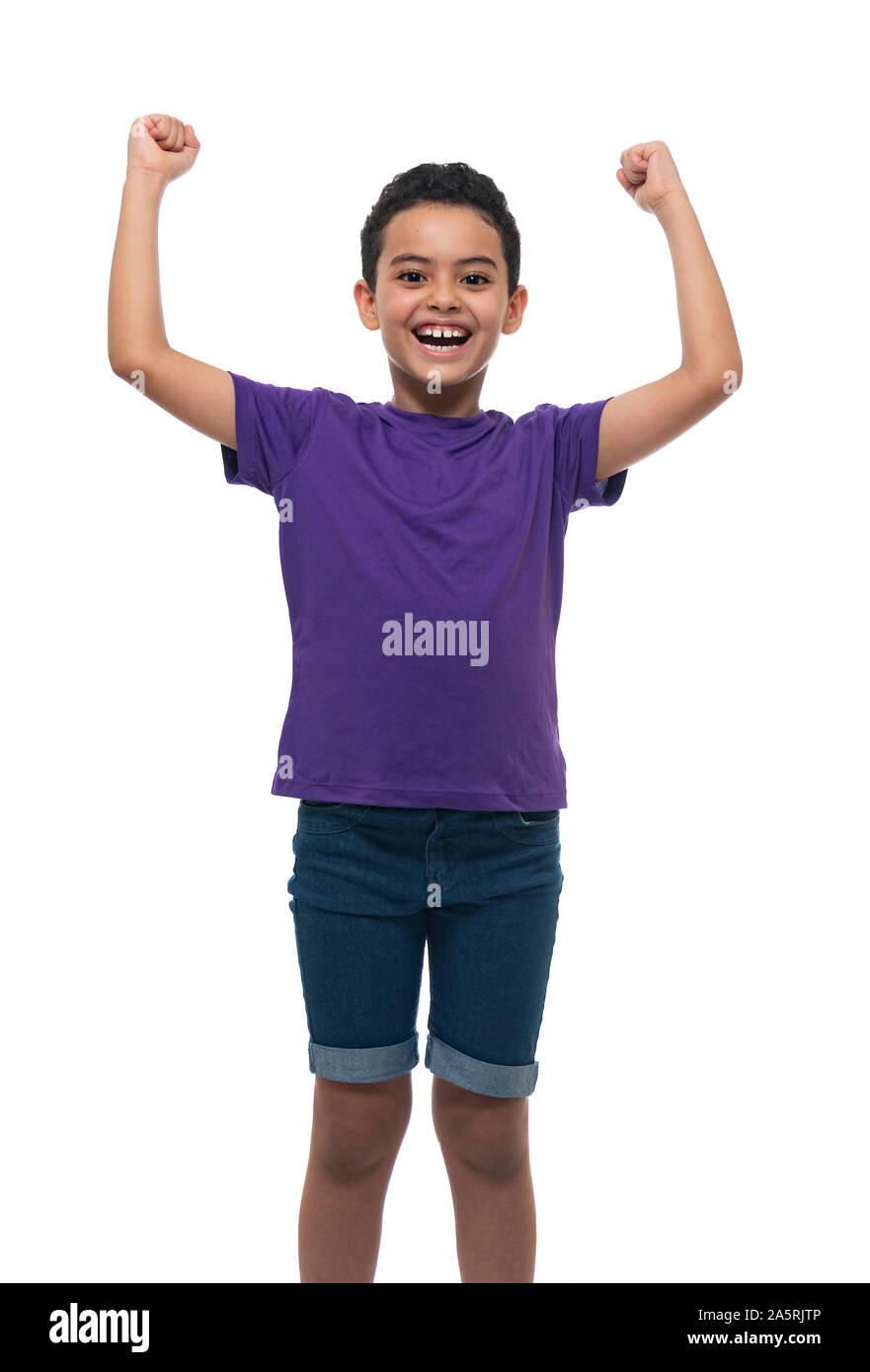 Feliz ganador joven muchacho celebrando su éxito, brazos arriba sobre fondo blanco. Foto de stock