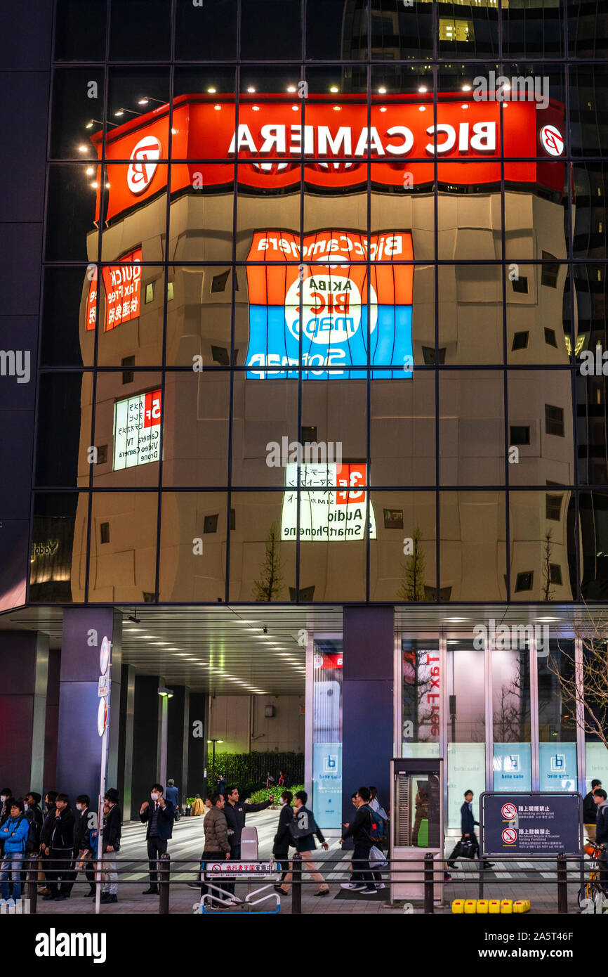 Tokio, Akihabara. Chuo Dori street. Bic Camera superstore edificio reflejado en los cristales tintados de cuadra de oficinas. Por la tarde. Pavimento lleno Foto de stock