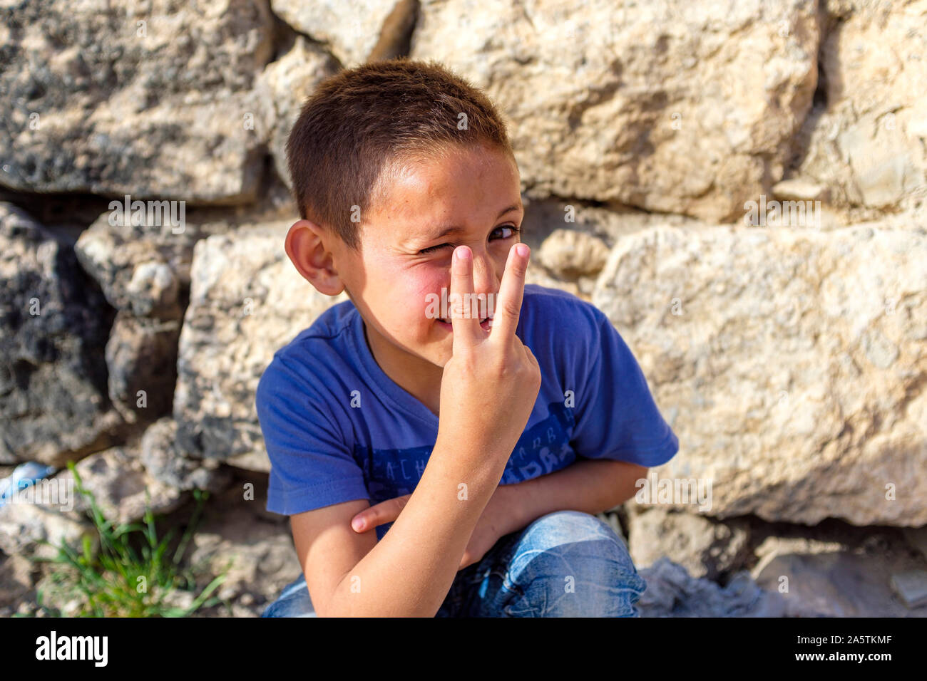 Niño Palestino haciendo gestos de paz o señal de victoria, ad-Dhahiriya, gobernación de Hebrón, en la Ribera Occidental, Palestina. Foto de stock